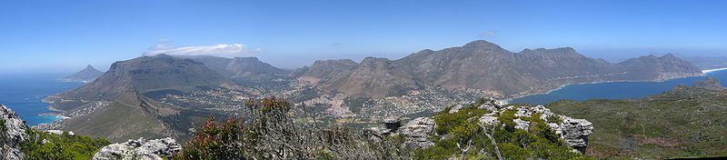 Image: Wikipedia Article/Public Domain/A panorama of Hout Bay, Cape Town, taken from Suther Peak, to the north-west of the village.